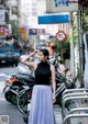 A woman standing in the middle of a busy street.