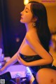 A woman in a black bathing suit sitting on a table.