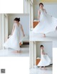 A woman in a white dress is dancing in a room.
