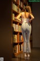 A woman standing in front of a bookshelf in a library.