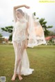 A woman in a white lingerie standing in a field.